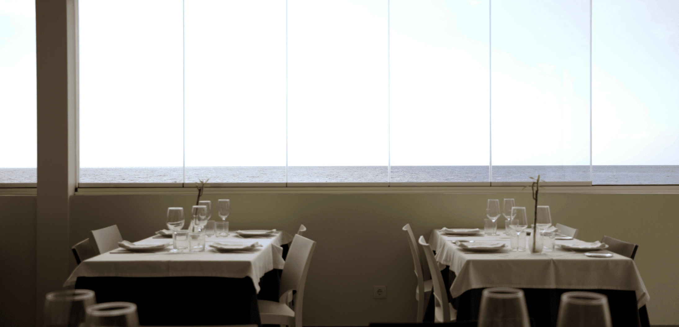 Detalle de la ventana de un edificio entre las ramas de los árboles.