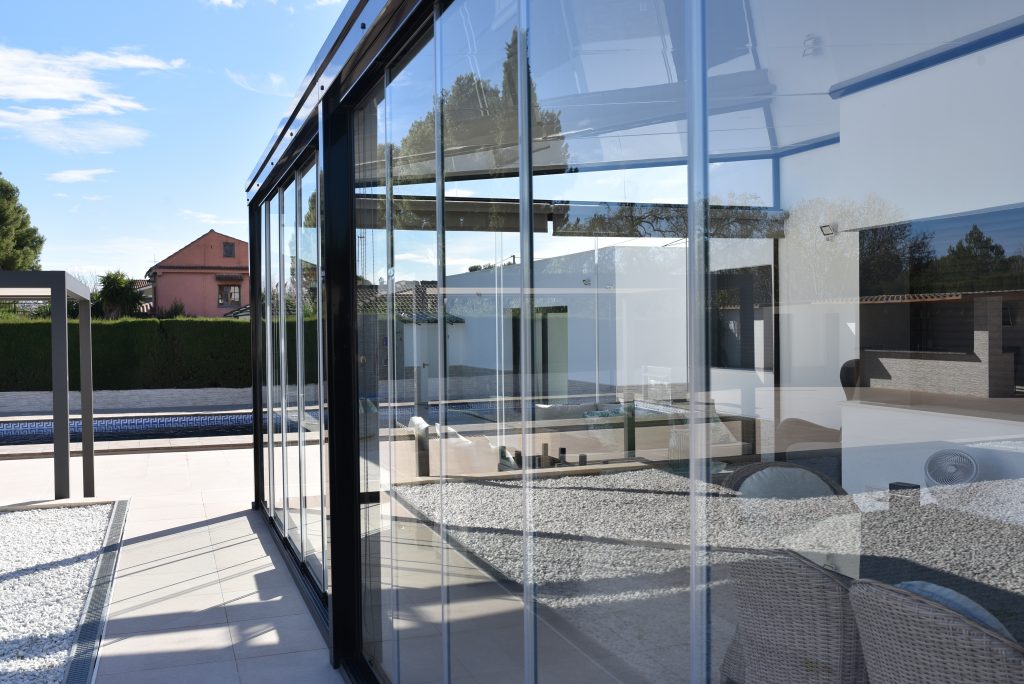 La diferencia entre una cortina de cristal corredera y abatible radica fundamentalmente en los sistemas de apertura